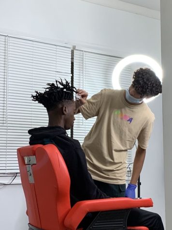 Moe Ramadan cuts a fellow students hair at his home barbershop in Ocean City.