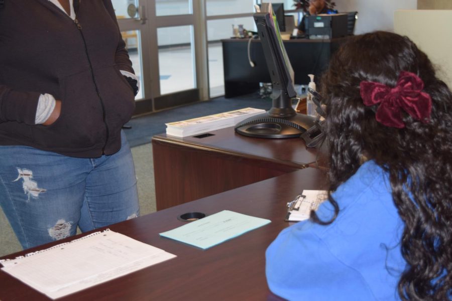 A student signs in with the front desk as being late on Sept. 27.