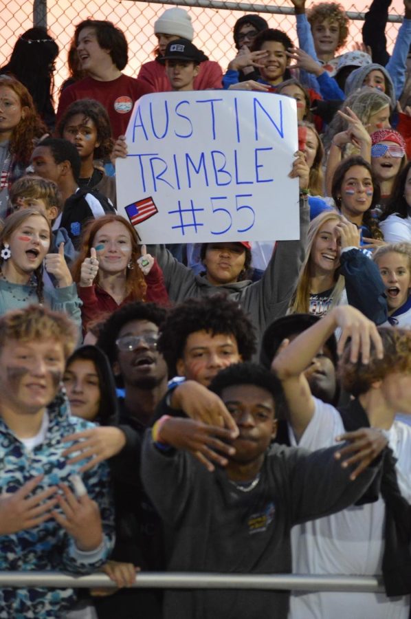 Students hold up a sign supporting senior Austin Trimble from the stands. 
