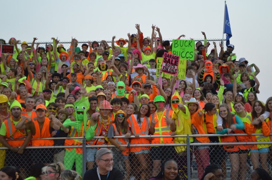 Students cheer during neon theme game. 