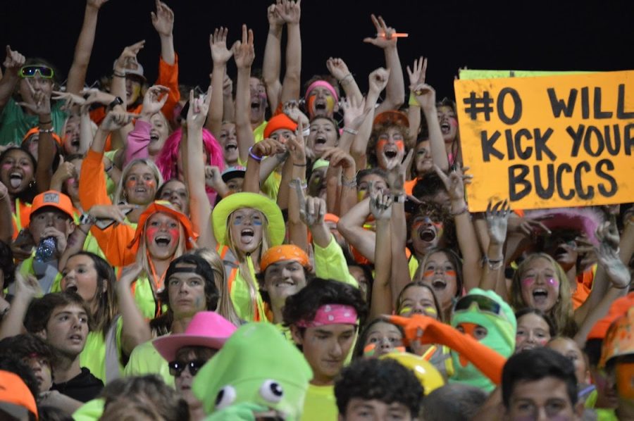 Students cheer during the neon theme game. 